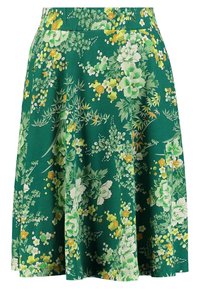 Falda verde con flores amarillas y blancas vibrantes, con un diseño acampanado. La tela muestra un exuberante patrón botánico.