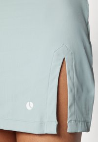 Svetlo modra, rebrasta športna krila z bočnimi razporki. Ima belo logo na spodnjem robu, ki prikazuje čiste linije in mehak material.