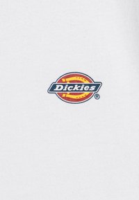 Vit bomull t-shirt med en färgglad cirkulär logotypdesign med varumärket "Dickies" i blå och gula accenter.
