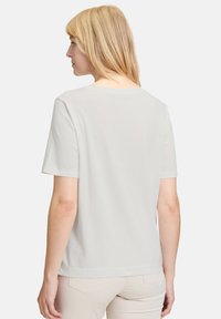 T-shirt gris clair à manches courtes avec une coupe décontractée, col rond et tissu en coton lisse. Design simple, sans motifs ni embellissements visibles.