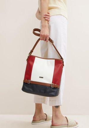 Rood, wit en marineblauw kleurgebroken schoudertas met een bruine strap en gespaccenten. Smooth textuur met een gestructureerde vorm.
