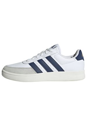 Sneaker bianco con strisce blu navy, materiali in pelle e suede, punta rotonda, suola piatta e design con lacci. Presenta dettagli perforati sui lati.