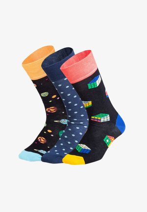 Tre paia di calzini con design colorati: neri con pianeti, blu navy con pois e neri con motivi del cubo di Rubik.
