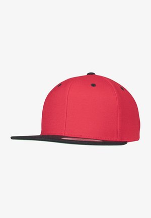 Casquette snapback rouge avec visière plate noire, fabriquée en tissu texturé. Équipée d'œillets noirs et d'un design de couronne arrondie.