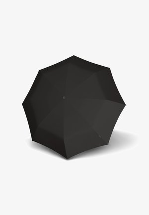 Schwarzer offener Regenschirm von oben gesehen mit acht Feldern und einem zentralen Knopf, wirft einen Schatten auf einen weißen Hintergrund.