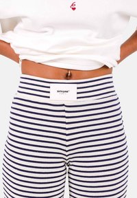 Gebreide broek met marineblauwe en witte horizontale strepen, met een brede elastische tailleband en een label met de tekst "SIXTH JUNE PARIS."