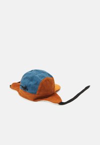 Chapeau en velours côtelé avec des panneaux bleus et orange, visière plate, côtés allongés et sangle de menton noire. Tissu texturé avec une doublure douce.