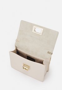 Béžová kožená kabelka s hladkým povrchem, zlatými doplňky, obdélníkovým tvarem a bezpečným zapínáním. Uvnitř má měkkou podšívku.