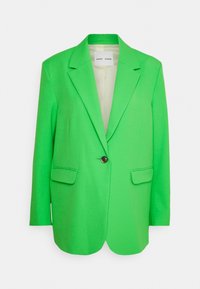 Blazer verde con revers a punta, chiusura a un bottone e due tasche frontali; texture liscia e design su misura.