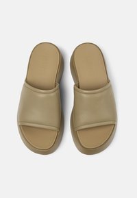 Sandali infradito in pelle beige con una fascia ampia e una suola imbottita. Design a punta arrotondata con una superficie liscia e senza hardware visibile.