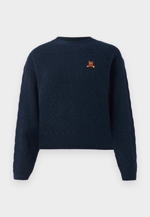 Marineblå kabelstrikket sweater med rund hals og lille broderet teddybjørn med rød sløjfe på venstre bryst.