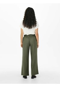Olive green wide-leg trousers with a soft texture, elastic waistband, and subtle pleating, paired with a loose-fitting white top.
