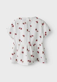 Top bianco a maniche corte con silhouette a skater. Decorato con stampe di fragole rosse sparse. Presenta un collo rotondo e chiusura con bottone sul retro.