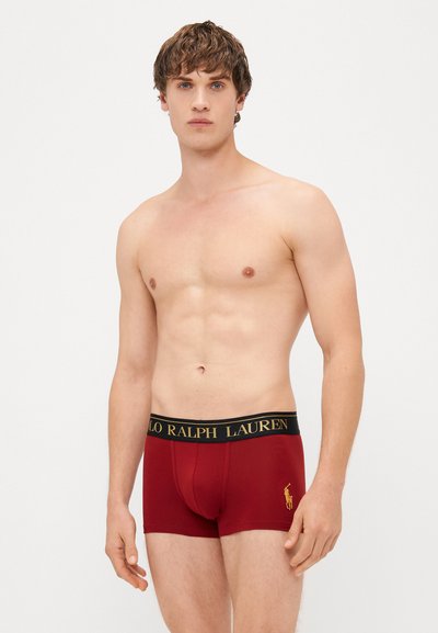 Boxer ajustados de algodón rojo con un diseño ceñido, una banda elástica negra que presenta el texto dorado "Polo Ralph Lauren" y un pequeño logo en el lateral.