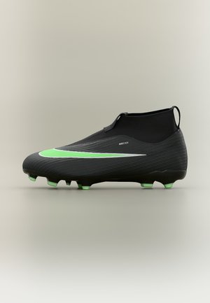 Crampon de football Nike noir avec un swoosh vert et blanc, un col cheville style chaussette et des crampons verts sur la semelle.