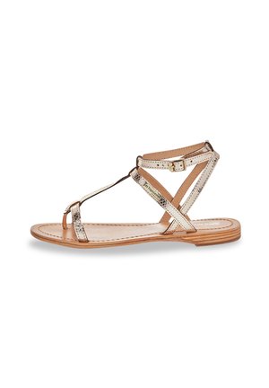 Sandalo flat con cinturini in oro metallizzato e beige, caratterizzato da un design a T, fibbia regolabile alla caviglia e una soletta leggermente imbottita.