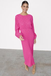 Fuchsia long-sleeve dress with pleated texture and gold dot pattern; features a round neckline and flowing silhouette, paired with beige shoes.