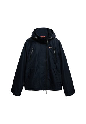 Giacca impermeabile blu navy con cappuccio, chiusura frontale con zip e numerose tasche con zip. Presenta cordini regolabili e tessuto testurizzato.