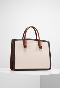 Beżowa skórzana torebka z brązowymi akcentami i teksturowanymi ciemnymi brązowymi krawędziami. Posiada dwa zaokrąglone uchwyty oraz sztywny prostokątny kształt.