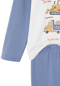 Children’s pajama set with light blue sleeves and pants, white torso featuring yellow and blue construction vehicle illustrations and sound effects.