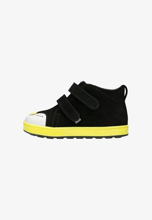 Schwarze Kindersneaker mit doppelten Klettverschlussriemen, weißer Zehenkappe und leuchtend gelber Sohle, Seitenansicht.