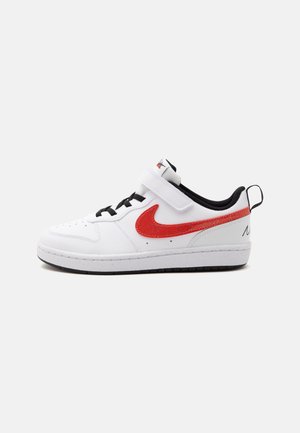 Biały niskoprofilowy sneaker z czarną podeszwą, czarnymi sznurowadłami, czerwoną łyżwą Nike i rzepem, pokazany z profilu na jednolitym tle.