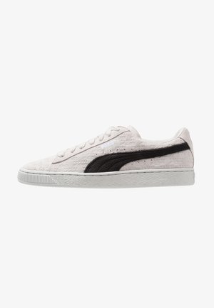 Light gray textured sneaker with a black suede stripe, white rubber sole, and flat laces, featuring subtle branding on the side.