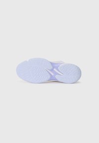 Semelle d'une sneaker, présentant un dessous en caoutchouc texturé de couleur violette avec un grip à motifs, et une section de connexion lisse.