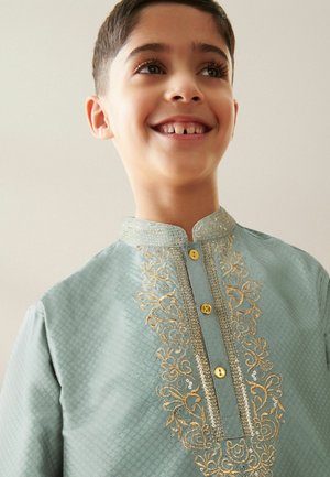 Chemise traditionnelle turquoise avec broderies dorées et accents métalliques, un col montant et des boutons décoratifs sur le devant.