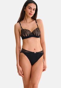 Zwart lingerie-set met een doorschijnende kant bh met bloemmotief en verstelbare bandjes, gecombineerd met bijpassende slip met kantafwerking.