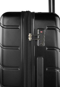 Maleta rígida negra con una superficie texturizada, cierre de doble cremallera y candado de combinación integrado. Cuenta con un asa resistente y ruedas.