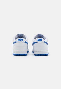 Weiße Nike-Sneaker mit blauen Akzenten, ausgestattet mit einem glatten Lederobermaterial, gepolstertem Kragen und einer Gummisohle mit strukturiertem Profil.