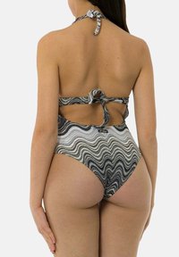 Bikini a zigzag bianco e nero, con scollo a halter, design con schiena scoperta, tessuto testurizzato e dettaglio con strap da annodare sul retro.