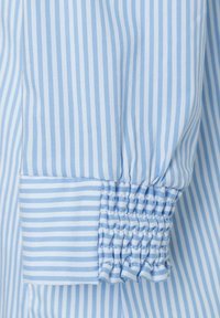 Light blue and white striped fabric with gathered cuff detail. The material is smooth with a uniform texture and evenly spaced stripes.