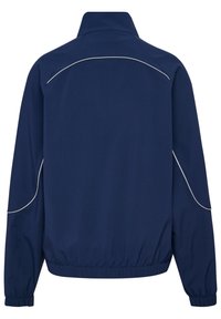 Marinblå jacka med ståkrage, elastiska ärmslut och nederkant, med subtila vita kantband längs axlarna och ryggen för kontrast.