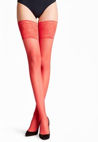 Red thigh-high stockings with floral lace trim at the top, smooth texture, and a sleek design, paired with black high heels.
