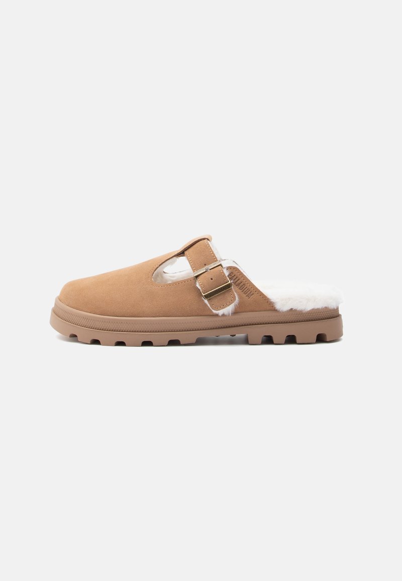 Barna velúr slip-on papucs fehér szőrme béléssel, állítható pánttal és texturált gumitalppal, amelyen kis tapadási bütykök találhatók.