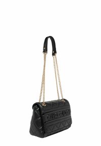 Zwarte doorgestikte schoudertas met gouden kettingbanden, voorzien van een gladde textuur en een geperst logo aan de voorkant. Rechthoekige vorm met afgeronde hoeken.