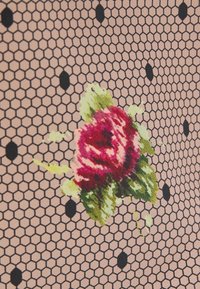 Tissu rose pâle avec un motif en maille hexagonale, comportant une rose rouge centrale et des feuilles vertes, accentuées par des points noirs.