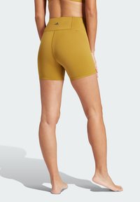 Shorts de sport kaki en tissu extensible, dotés d'une taille haute et de coutures minimales pour le confort et la mobilité.