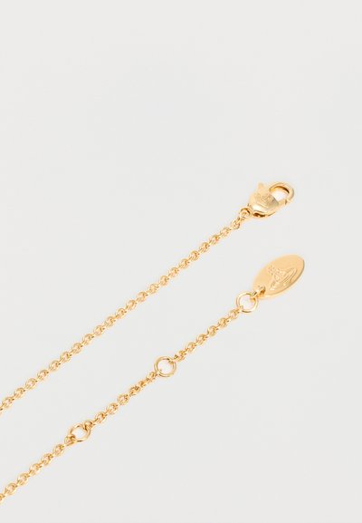 Finom aranylánc homárkapoccsal és ovális címkével, mindkettőn kis gömb és kereszt szimbólum gravírozással, fehér háttéren.