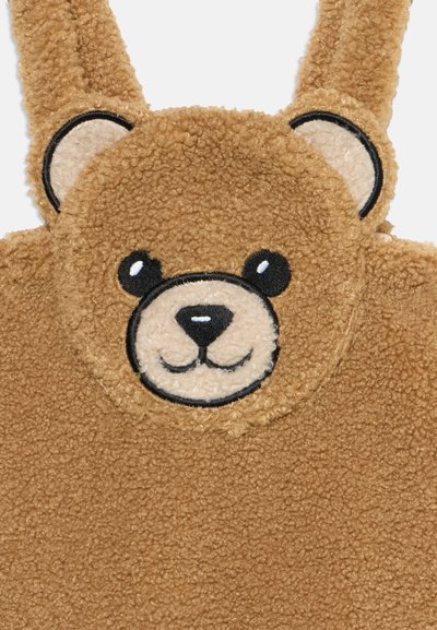 Καφέ πρόσωπο αρκούδας τύπου teddy με μαύρα μάτια, μύτη και στόμα σε απαλό, υφασμάτινο υλικό με προσαρτημένα αυτιά και λουριά.