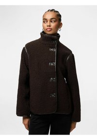 Rjava flis jakna z visokim ovratnikom, petimi gumbi in črnimi detajli. Ima mehak teksturo in sproščen kroj, idealna za toploto.
