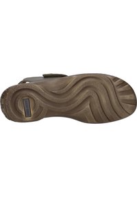 Hnědá gumová podešev s texturovanými drážkami a širokým vzorem tread. Obsahuje malou logovou destičku v oblasti paty. Zpevněné okraje pro větší odolnost.