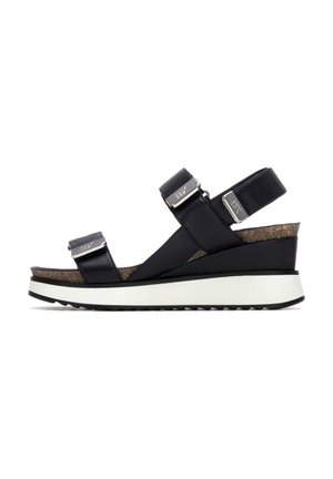 Sandalia de cuña negra con dos tiras ajustables con hebillas de metal y plantilla de corcho sobre suela plataforma blanca y negra.