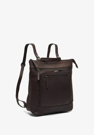 Sac à dos en cuir marron foncé avec plusieurs compartiments zippés et bretelles réglables, debout sur un fond blanc.