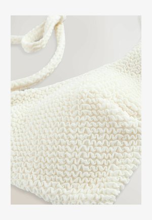 Kremowy biustonosz bikini z teksturowanym, falbaniastym wzorem. Regulowane ramiączka rozciągają się od góry, poprawiając ogólny dopasowanie i wygląd.