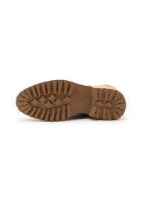 Suela de goma marrón con un patrón de banda de rodadura profunda para agarre; cuenta con crestas planas y elementos de tracción circulares; marcada con la talla 38.