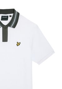Hvid polo-shirt med en mørkegrøn krave og stribede detaljer. Har et gult broderet logo på brystet. Korte ærmer.