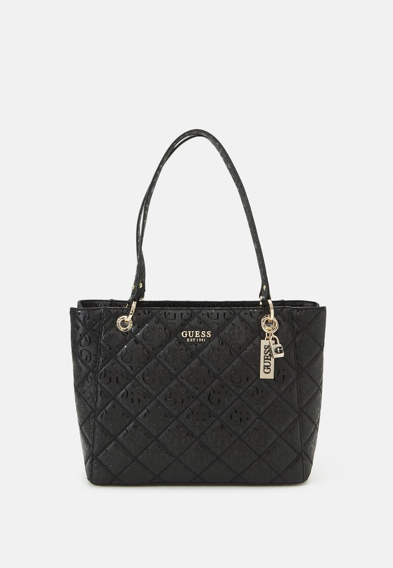 Sac cabas matelassé noir en cuir synthétique, avec une plaque logo dorée, deux poignées robustes et une étiquette porte-bonheur, au toucher lisse.